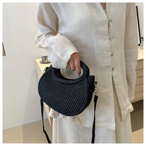 Detail showing a black sequin crescent handbag with vertical pleated textures and handle