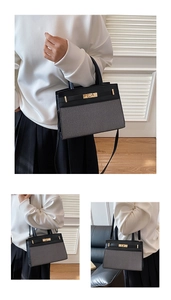Détail du sac cabas bicolore avec fermoir rotatif en métal doré et textures de tissu tissé