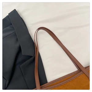 Close-up of brown tote bag with textured suede finish and fine edge stitching detail