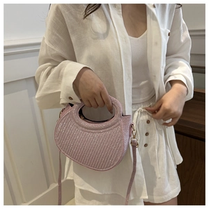 Close-up of sparkling pink crescent bag with rhinestones and golden hardware hooks