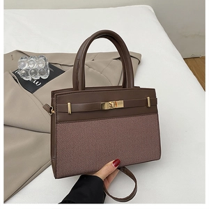 Détail du sac bandoulière marron café avec texture tissée et fermoir pivotant doré