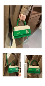 Detail showing the green leather and woven canvas stitching with gold buckle on handbag