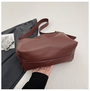 Detailed view of dark brown soft leather hobo bag showing adjustable gold strap buckle