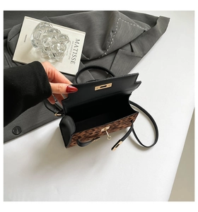 Macro view of leopard print bag with black leather flap and golden mechanical lock
