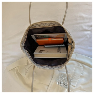 Top view of open beige monogram tote bag showing large capacity for books and tablet