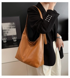 Detail of camel oversized tote bag with V-shaped stitching and wide adjustable strap