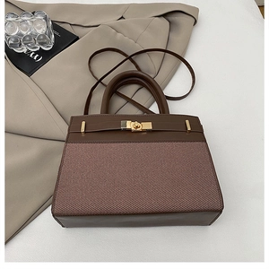 Détail du sac en cuir marron et toile avec fermoir doré et poignée supérieure