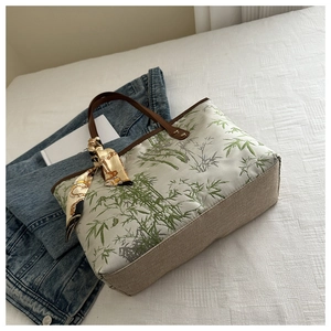 Detail of Chinese style tote bag featuring bamboo embroidery and silk scarf on handle