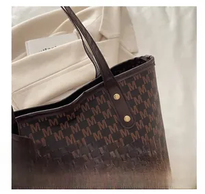 Detail view of reinforced gold studs and monogram leather texture on brown tote bag