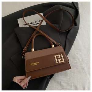Macro detail of brown leather bag with golden geometric buckle and textured stitching