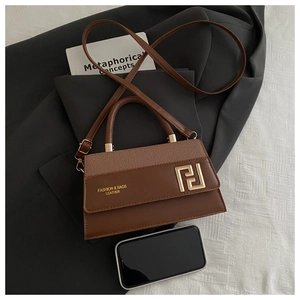 Macro detail of brown leather and fabric handbag featuring golden geometric hardware