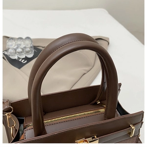 Vue détaillée du sac à main en cuir marron foncé avec ferrures dorées et double anses