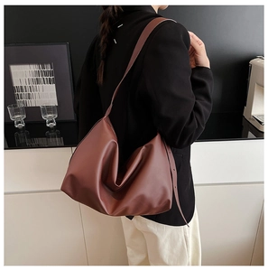 Brown matte leather tote bag shown on shoulder with minimalist drape and large capacity