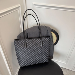 Large capacity tote bag with geometric patterns and long shoulder straps on a chair