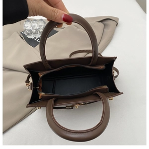 Vue de dessus d'un grand sac cabas en cuir marron avec fermeture éclair dorée et poche