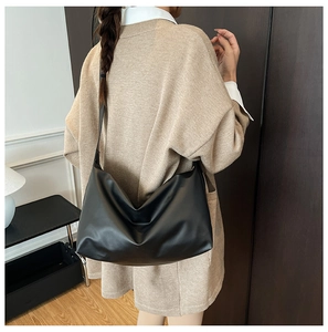 Detailed view of the large black matte leather shoulder bag with soft drape on a model