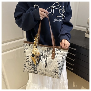 Detail of white tote bag with bamboo print and vintage patterned silk scarf on handle