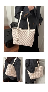 Détails du motif monogramme et pendentif en métal doré sur le cabas blanc