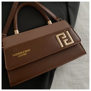 Detail of brown leather and woven texture handbag with golden geometric metal logo