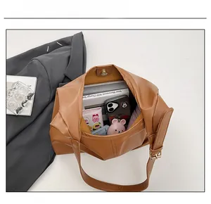 Detailed interior capacity showing the brown leather tote bag with books and accessories