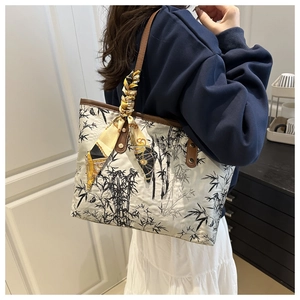 Détail du sac fourre-tout beige avec imprimé bambou à l'encre et accent d'un foulard en soie