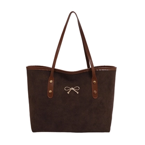 Minimalist dark brown suede tote bag with leather straps and golden bow hardware detail