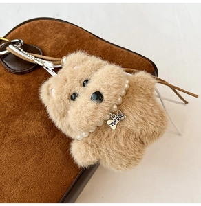Detail eines Plüsch-Hundeanhängers mit Perlenkette und Top Dog Metall-Knochenanhänger