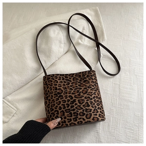 Detail of leopard print suede bucket bag with brown leather strap for autumn fashion