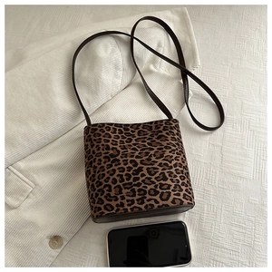 Detail of leopard print bucket bag on corduroy fabric with smartphone for size scale