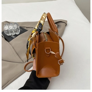 Détail du sac à main en cuir PU marron avec foulard décoratif et fermoir doré chic