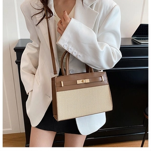 Sac à main bicolore porté en bandoulière dans un décor de bureau urbain et moderne