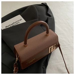 Detail of retro dark brown bag with woven texture, metal buckle and leather handle