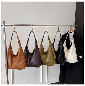 Five assorted colors of large Hobo shoulder bags hanging on a rack for daily use