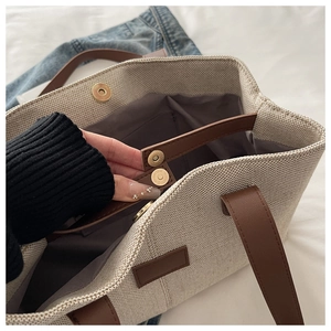 Detailed top view of linen tote bag showing magnetic buckle closure and durable brown handles