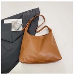 Detail of caramel faux leather bucket bag with adjustable strap and matte finish