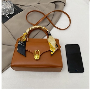 Vue détaillée du sac en cuir caramel avec poignée foulard et fermoir métallique doré
