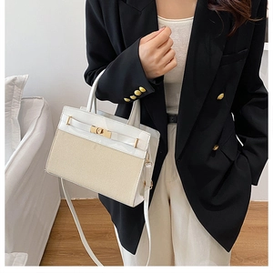 Détail montrant le contraste du cuir blanc et du tissu beige avec fermoir doré