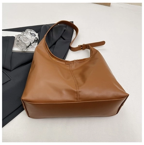 Detail of camel brown leather tote bag showing fine double stitching and adjustable strap