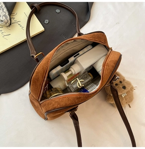 Innenansicht der großen Speicherkapazität einer braunen Boston-Handtasche aus Wildleder