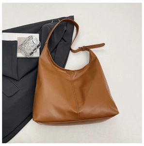 Top view of large brown faux leather tote bag with vertical stitching and adjustable strap