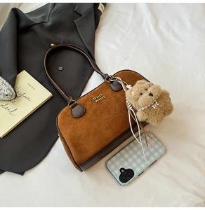 Detailansicht der braunen Wildleder-Schultertasche mit Miu Miu Logo und Bärenanhänger