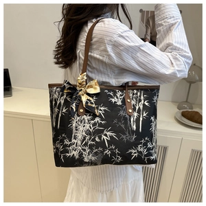 Détail du grand sac cabas noir avec imprimé bambou blanc et anses en cuir marron