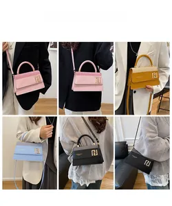 Détail d'un sac à main en cuir élégant avec poignée ronde, logo en métal et bandoulière