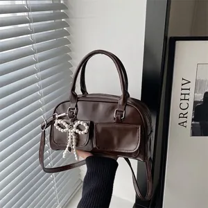 Dark brown leather Boston bag with pearl bow charm and dual front flap pockets