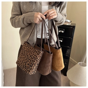 Close-up of stylish suede tote bags in leopard and brown tones with slim straps