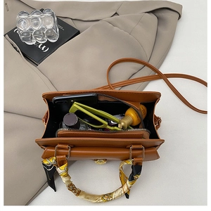 Vue détaillée du compartiment intérieur et de la poignée en soie de ce sac marron