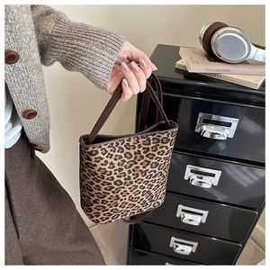 Detail of vintage leopard print tote bag with slim dark brown handle and retro style