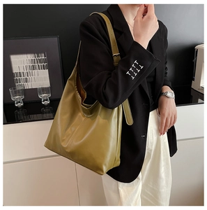 Olive green large capacity tote bag shown on shoulder of model in a black blazer