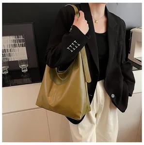 Olive green hobo bag featuring vertical stitching and adjustable shoulder strap on model