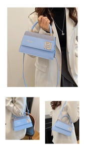 Détail du sac carré bleu clair avec fermoir doré et bandoulière amovible réglable